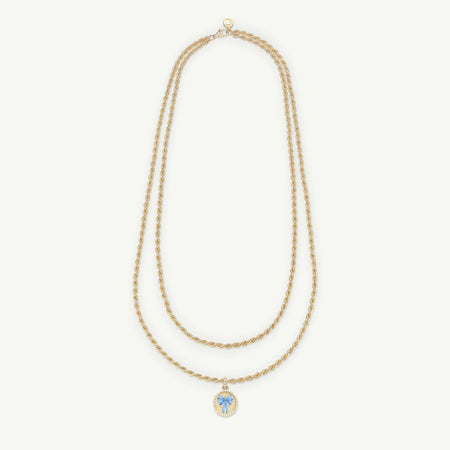 Gold rope necklace featuring a blue enamel bow pendant.