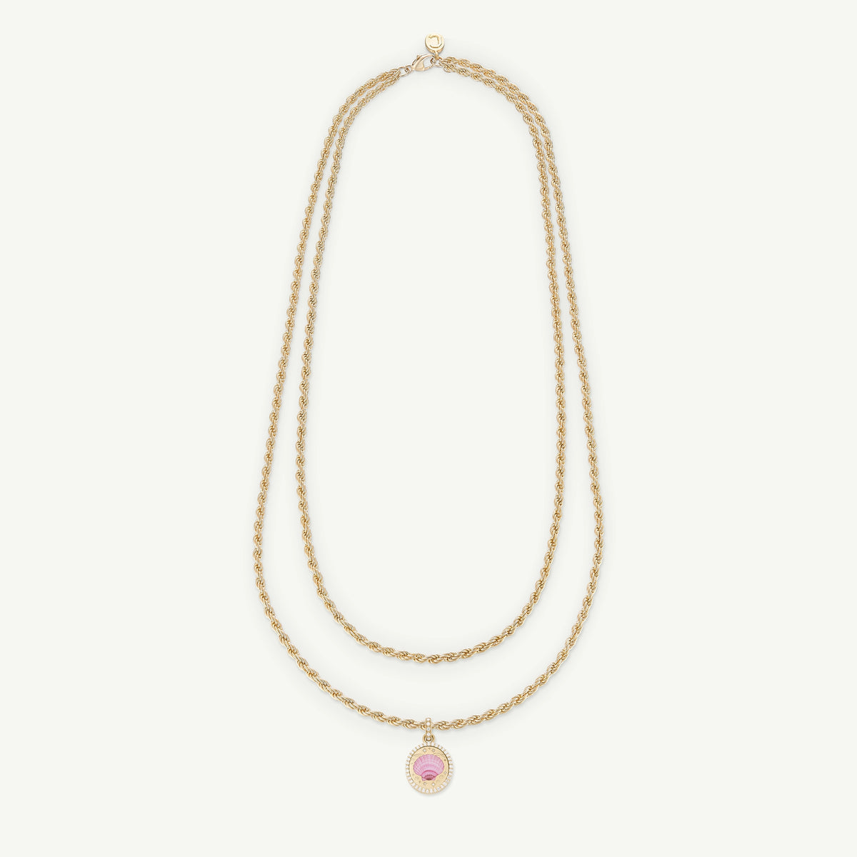 Gold layered necklace featuring a pink enamel charm and twisted chain design.