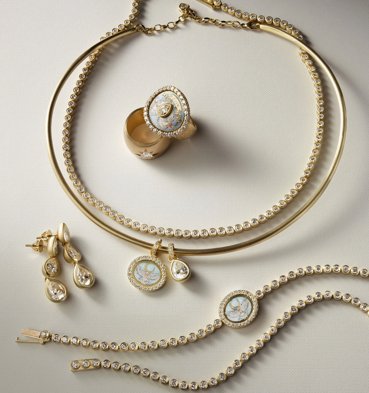 Gold jewellery set featuring a gold ring with a diamond, a gold choker, gold drop earrings, and gold bracelets with decorative elements.