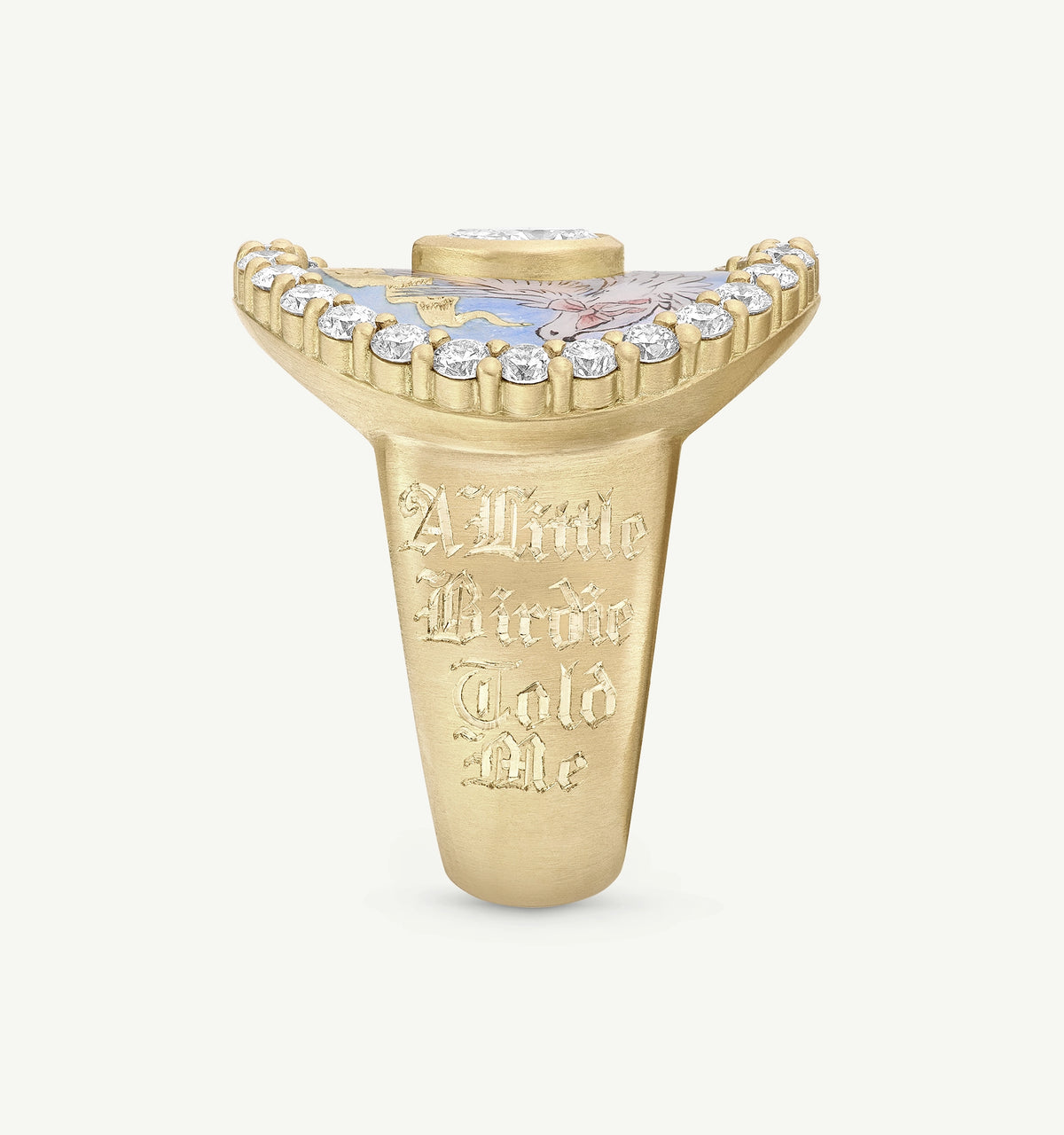 Gold ring featuring a painted floral design on top and engraved text "A Little Birdie Told Me" on the side.