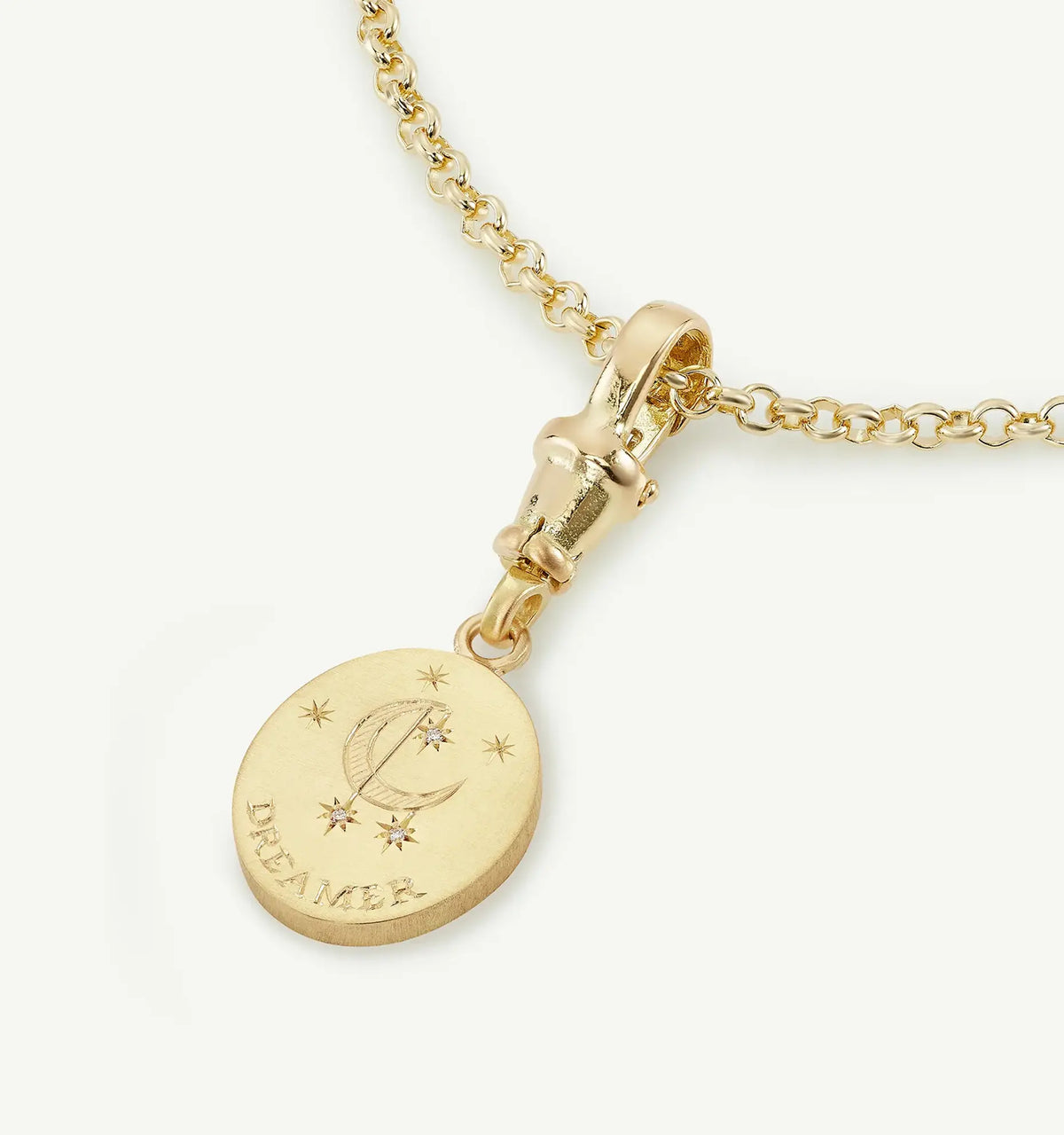Gold necklace featuring an engraved moon and star design with the word "DREAMER."