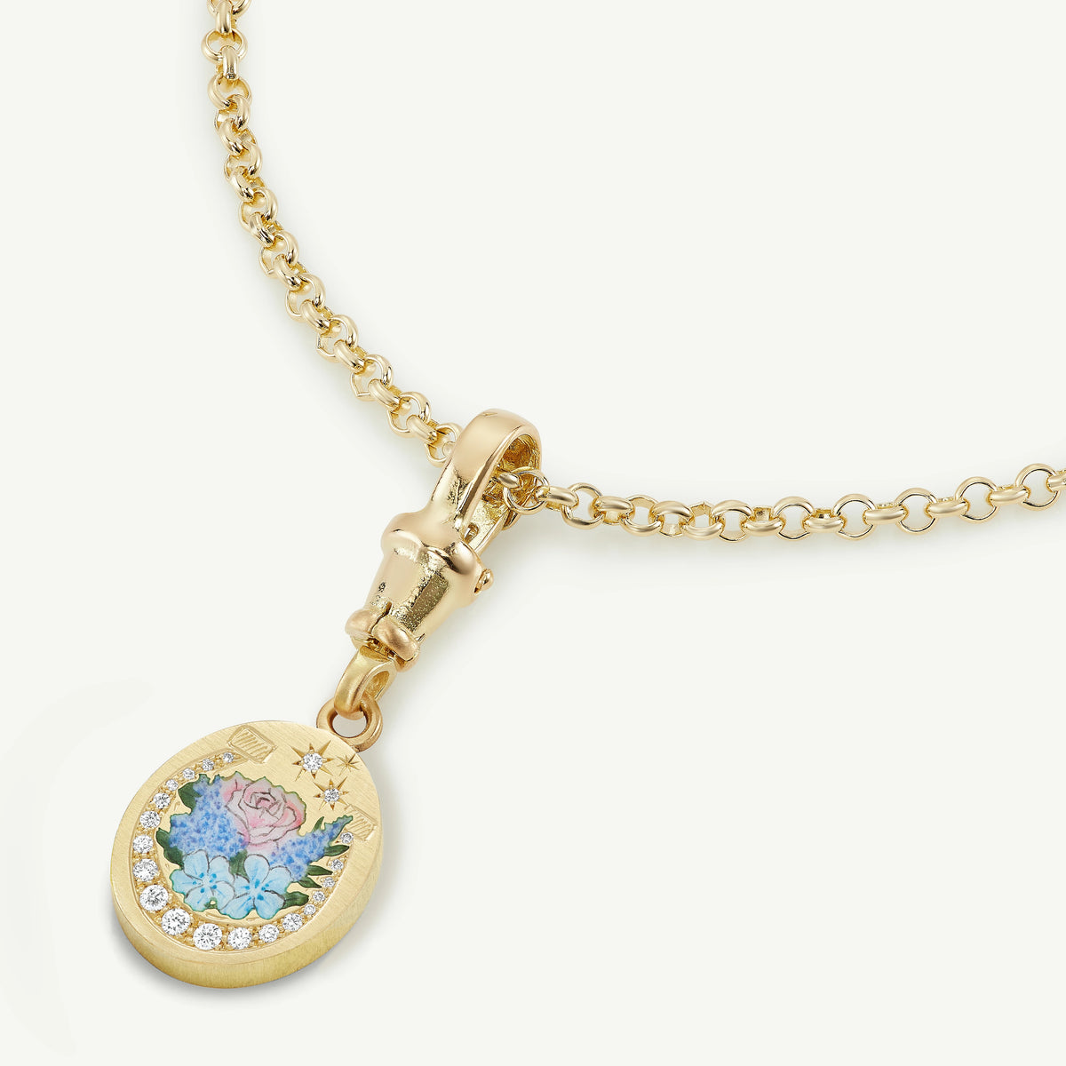Gold pendant with floral enamel design on a gold chain necklace.
