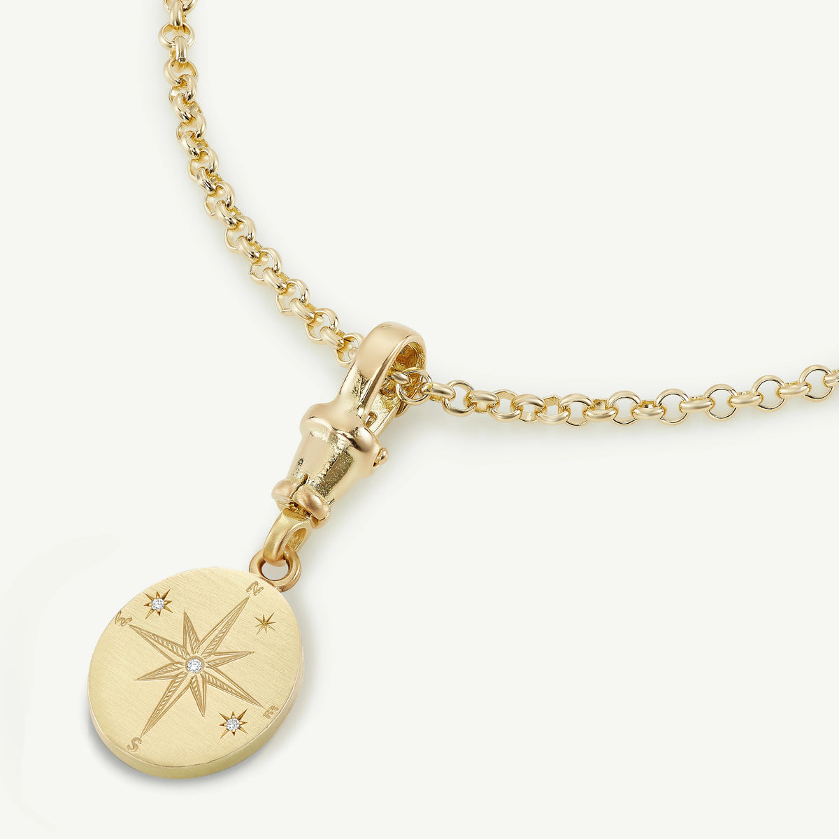 Gold necklace featuring a compass pendant with three diamonds.