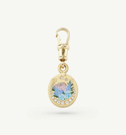 Gold charm featuring painted floral design and diamonds.