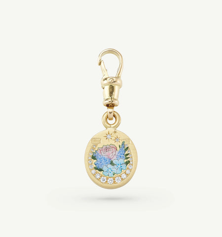 Gold charm featuring painted floral design and diamonds.