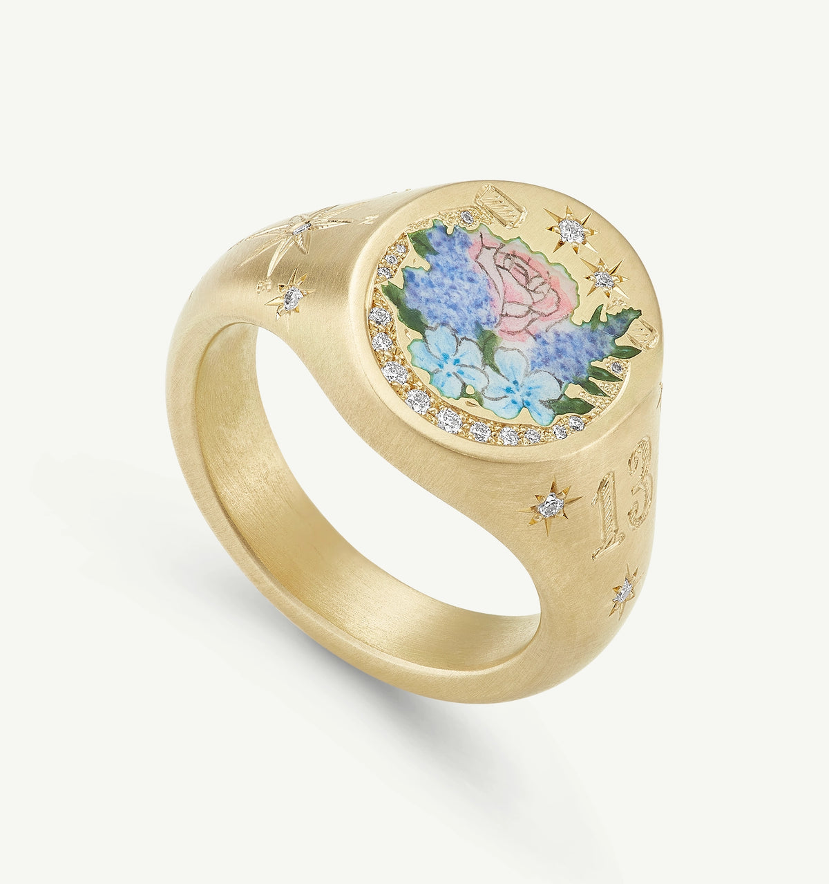 Gold signet ring with floral enamel design and diamond accents.