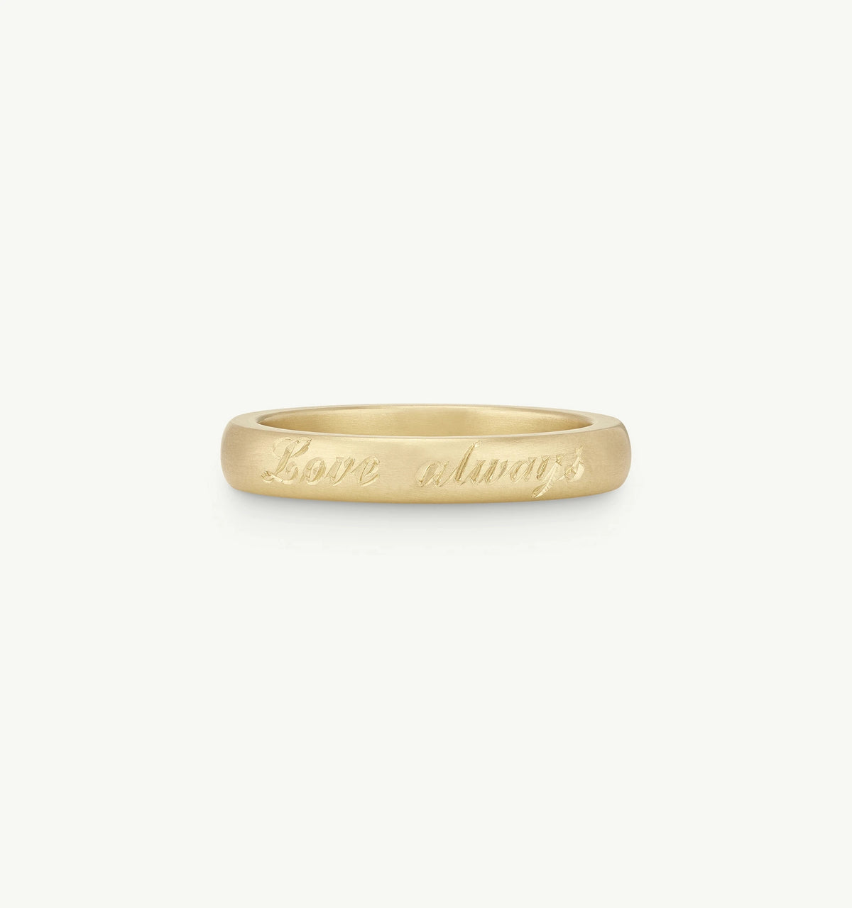 Gold band ring with an engraved message saying "Love always."