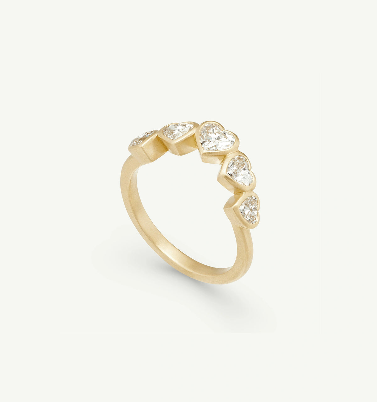 Gold ring featuring multiple heart-shaped diamonds set in a row.