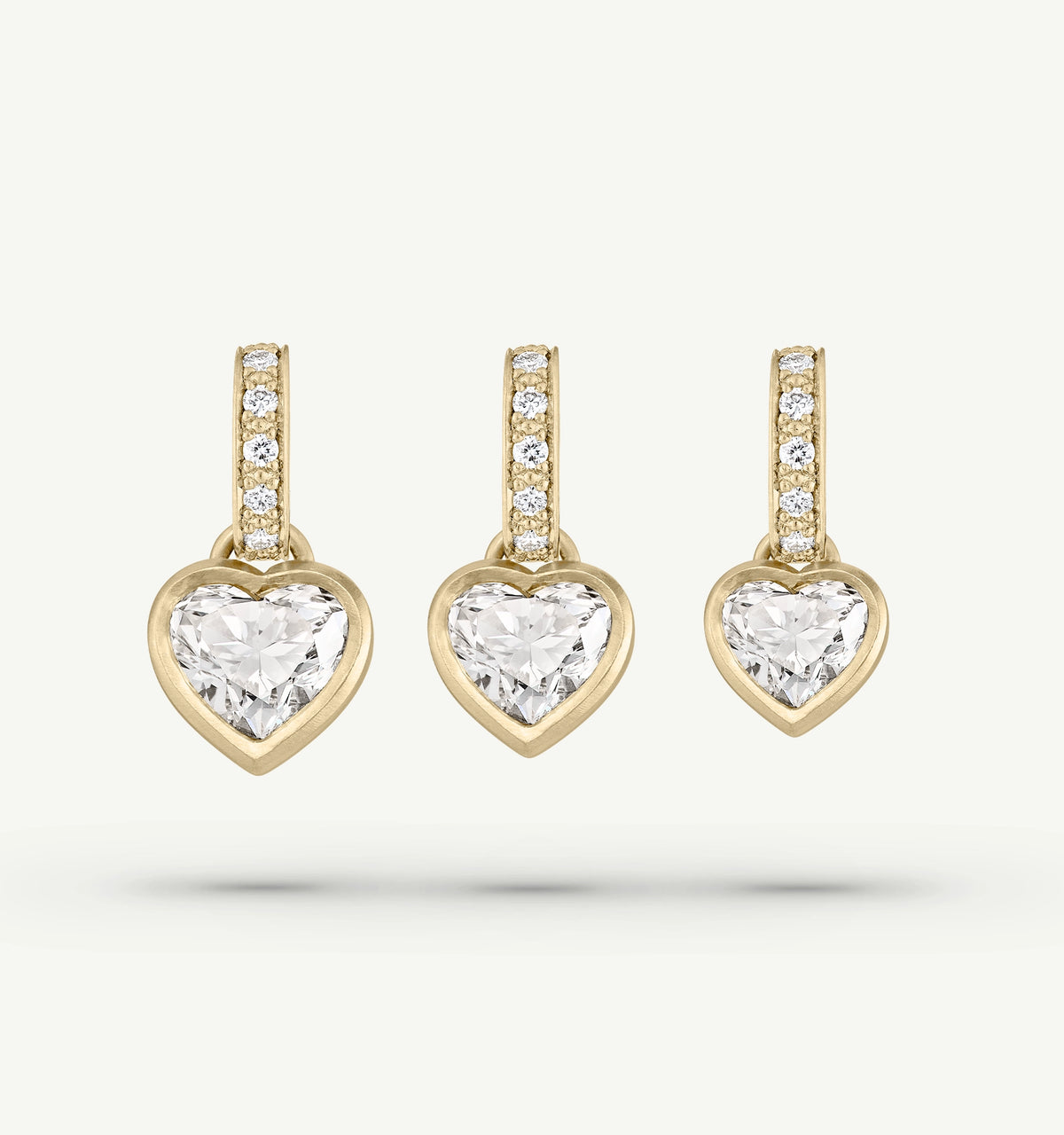 Gold heart-shaped earrings featuring clear diamonds on a delicate gold hoop.