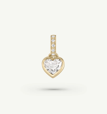 Gold heart pendant featuring a large clear stone and a diamond-accented bail.