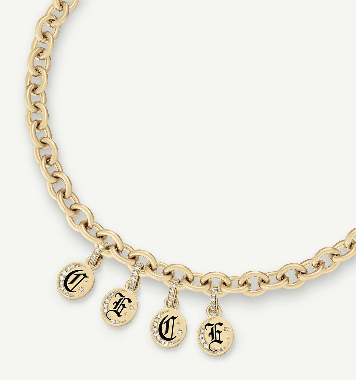 Gold chain necklace featuring four personalized circular charms with black lettering and small diamond accents.
