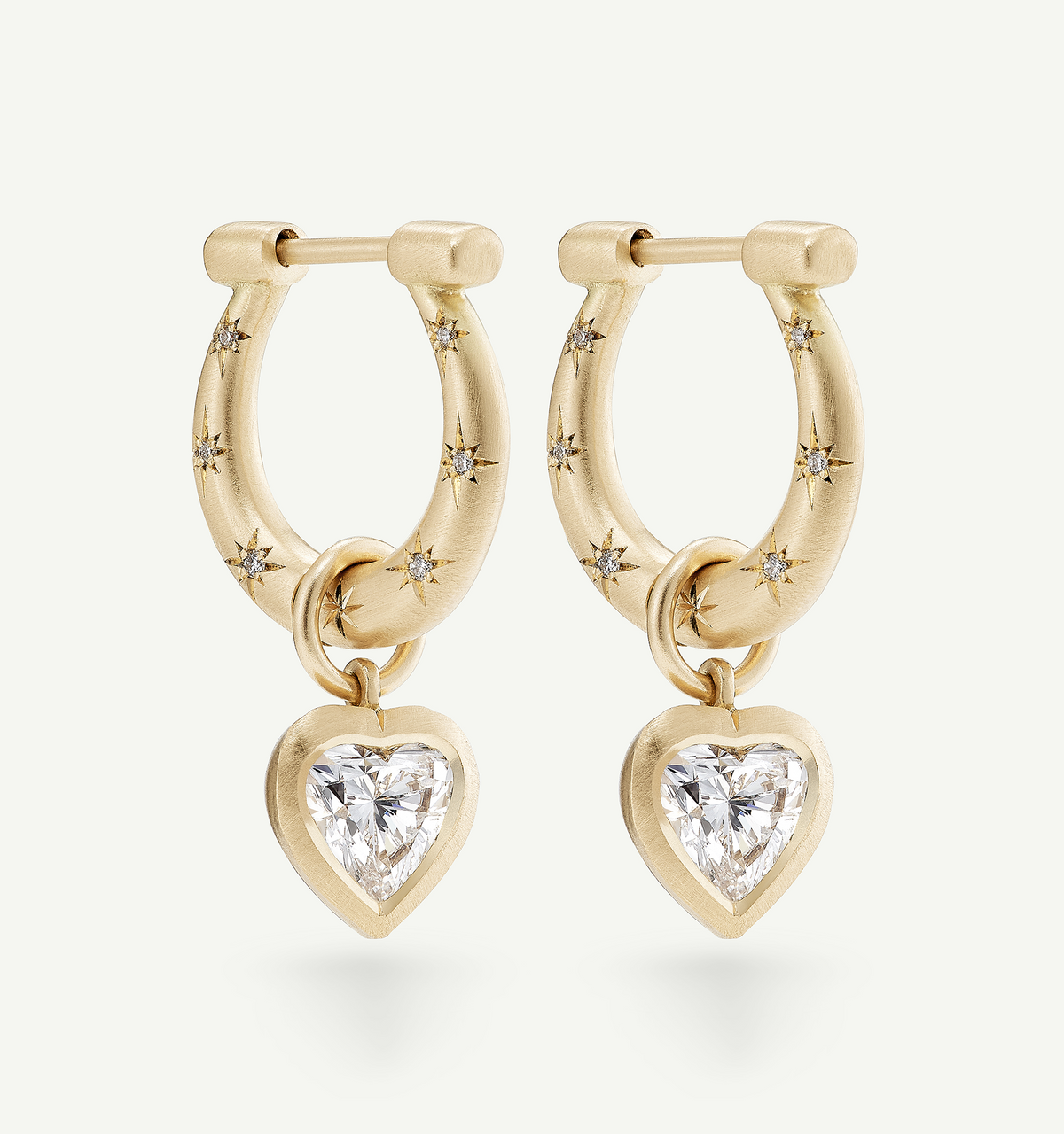 Gold hoop earrings featuring heart-shaped diamonds and star accents.