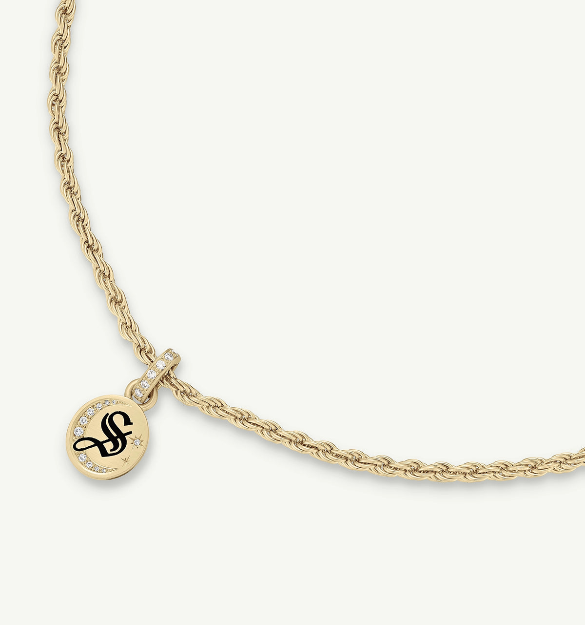 Gold necklace with a twisted chain and a round pendant featuring an engraved design and small diamonds.