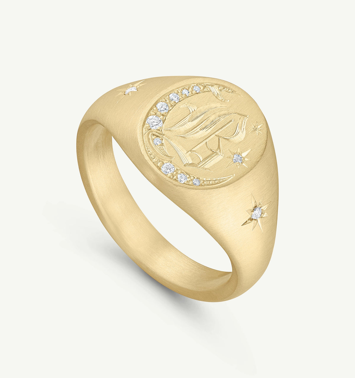 Gold signet ring featuring an engraved design and diamonds set around the face and on the band.