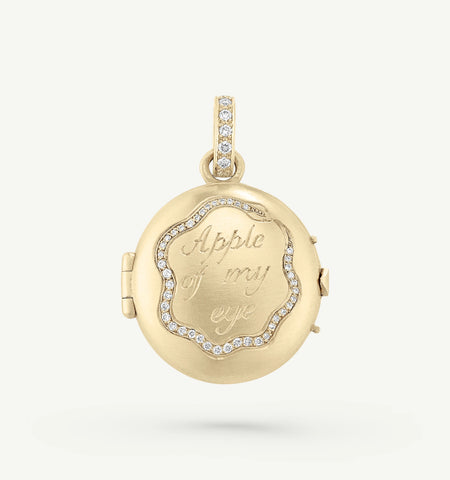 Gold locket featuring engraving "Apple of my eye" and a diamond-encrusted border.