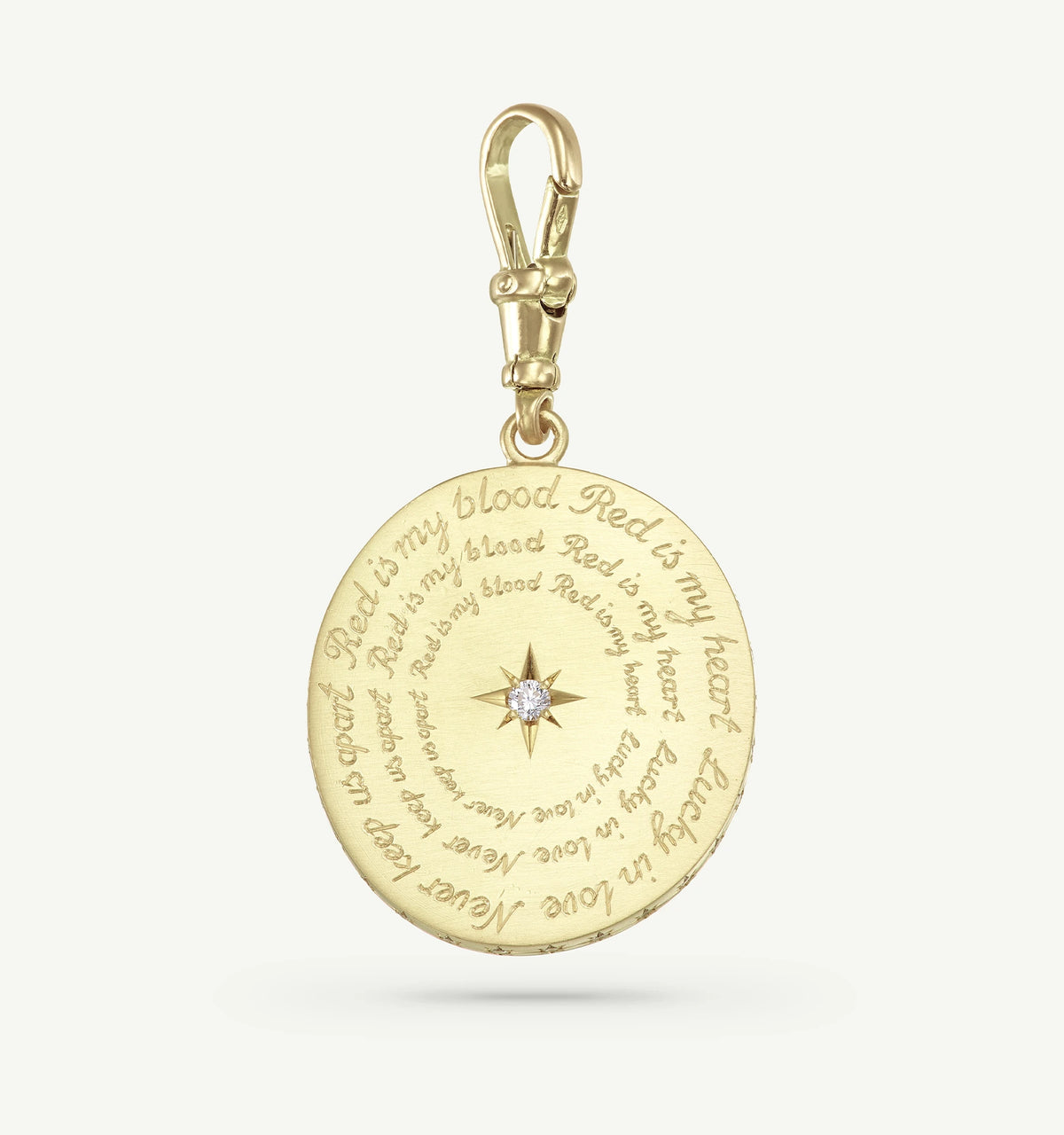 Gold pendant featuring engraved text and a central diamond accent.
