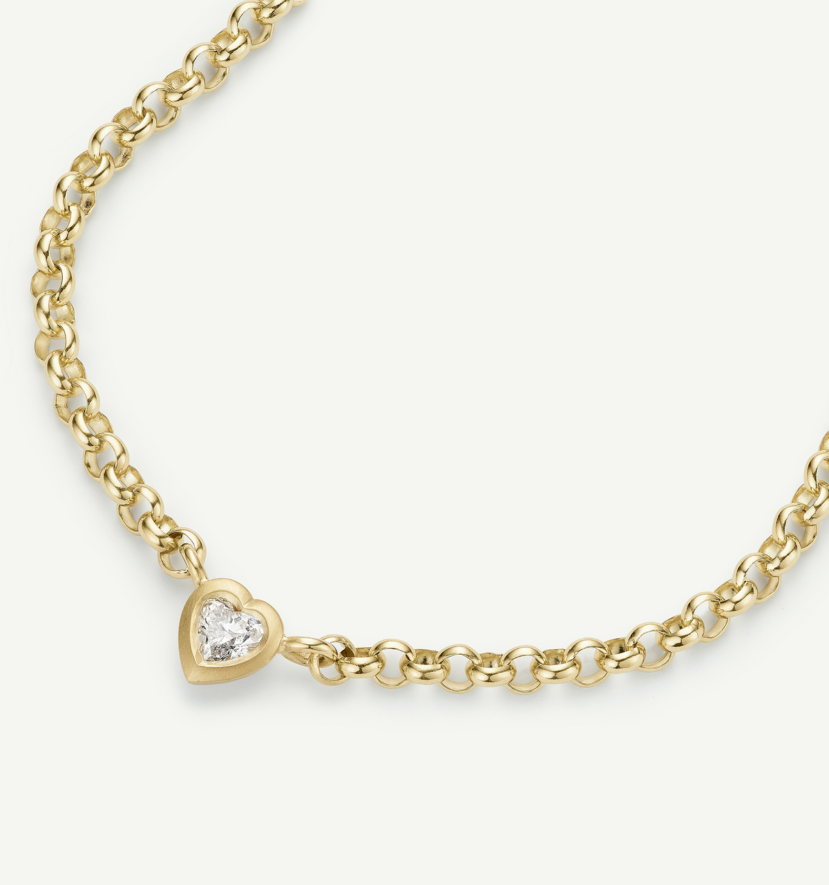 Gold chain bracelet featuring a heart-shaped pendant with a clear diamond.
