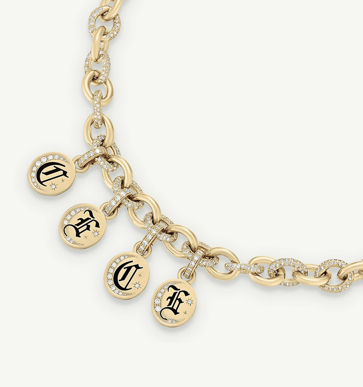 Gold chain necklace featuring four charm pendants with black lettering and diamonds.