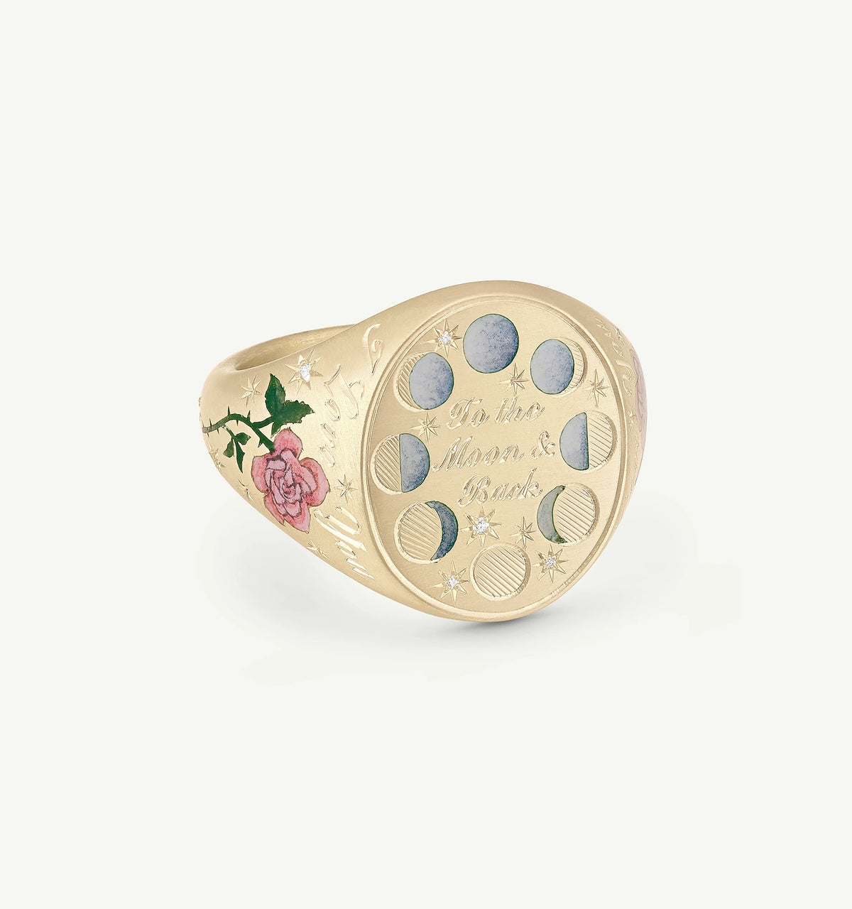 Gold ring featuring engraved phases of the moon and a rose design in enamel.