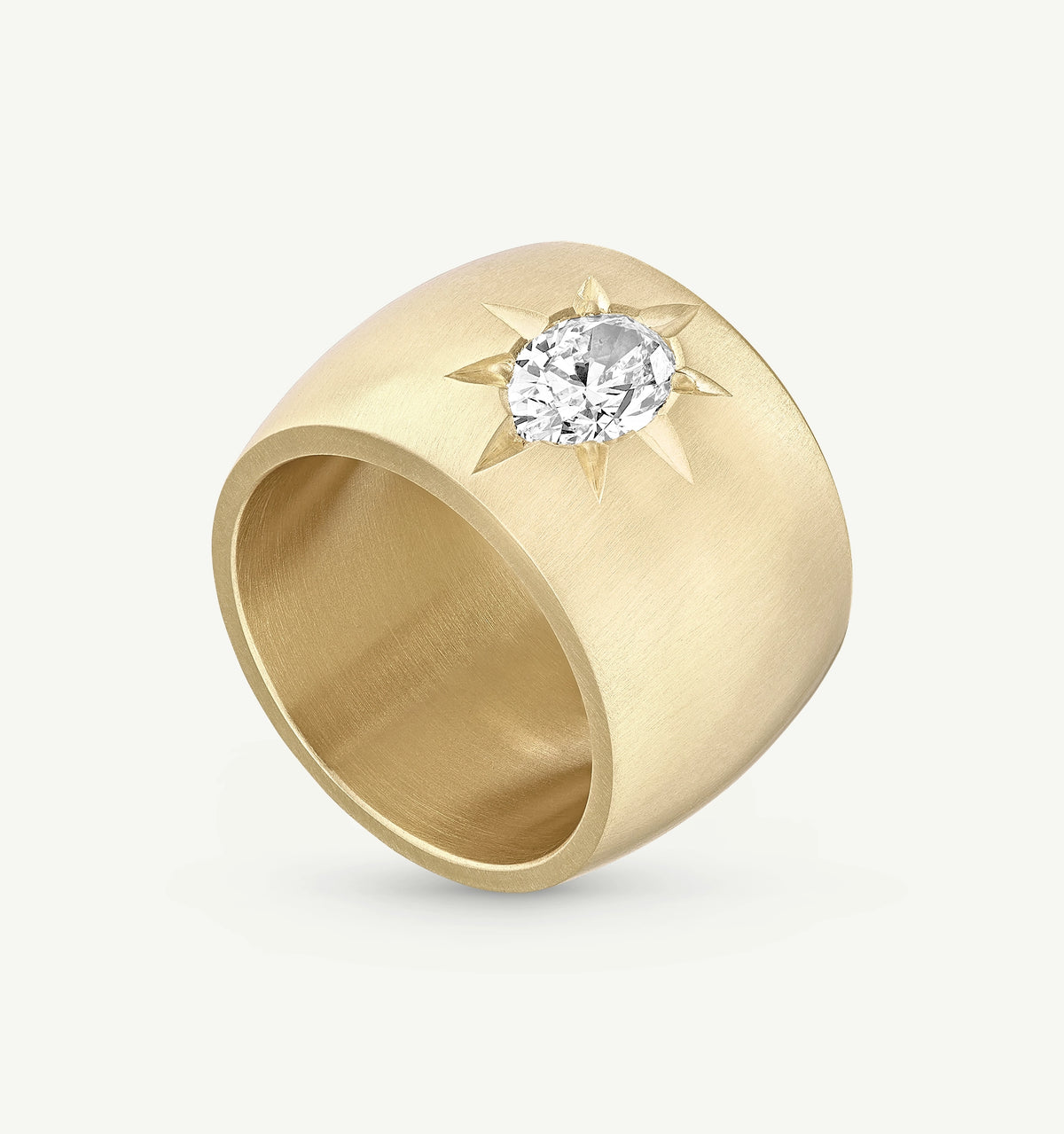 Gold ring featuring an oval diamond set within a sunburst design.