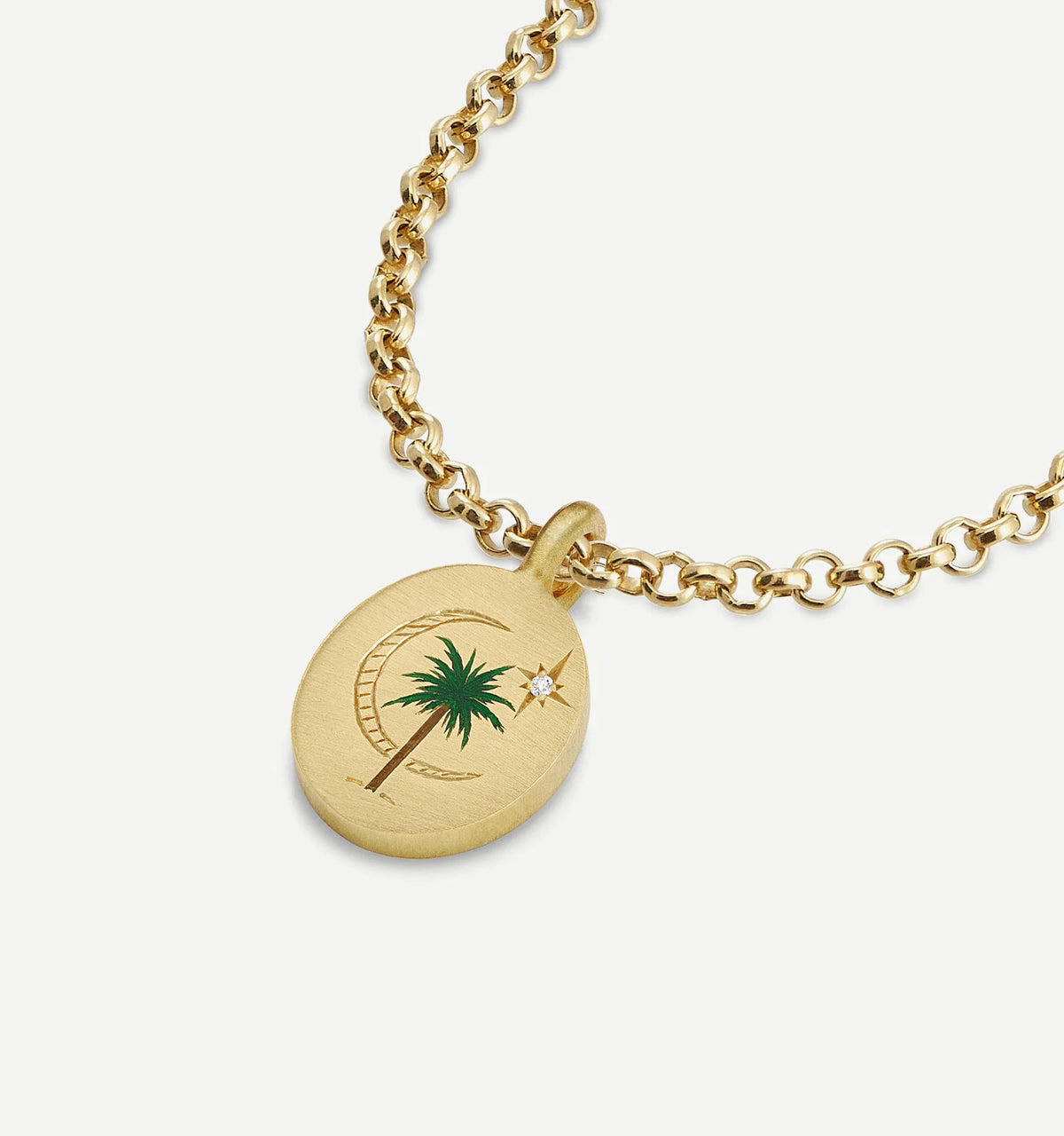 Gold necklace featuring an oval pendant with a palm tree and engraved details, embellished with a diamond.
