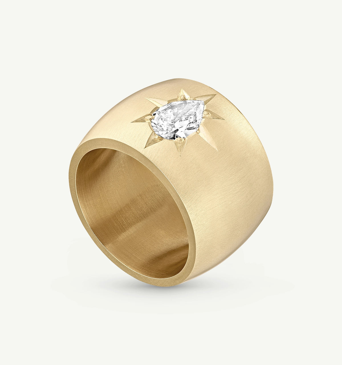 Gold ring featuring a pear-shaped diamond set in a star design.