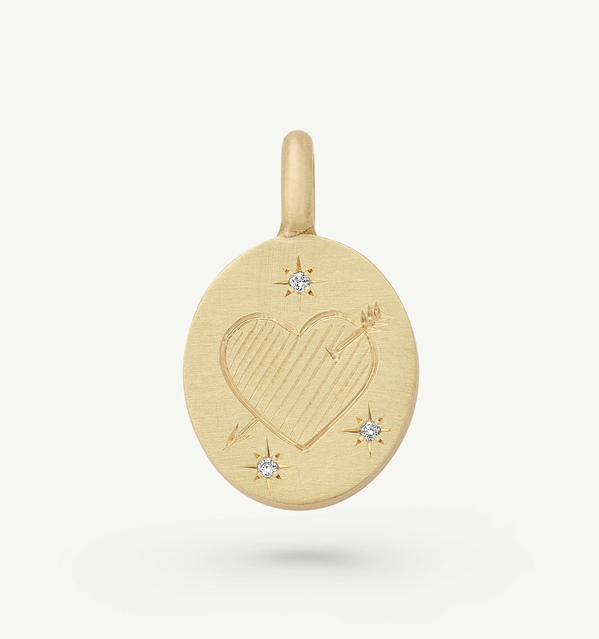 Gold pendant featuring an engraved heart design alongside small diamonds.