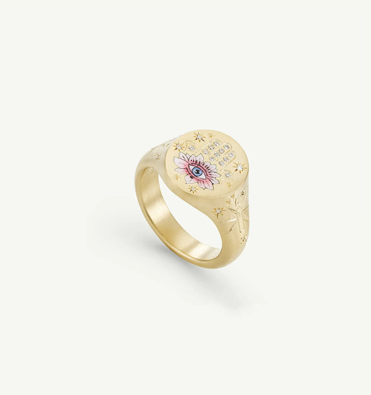 Gold ring featuring an eye motif and a pink lotus design, with engraved stars embellishing the surface.