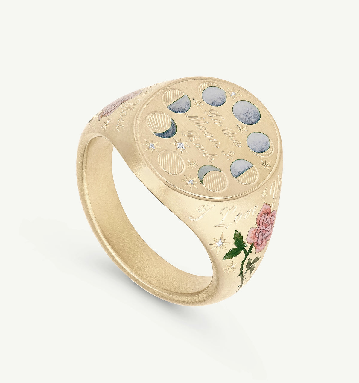 Gold signet ring featuring engraved moons, stars, and a rose with enamel details.