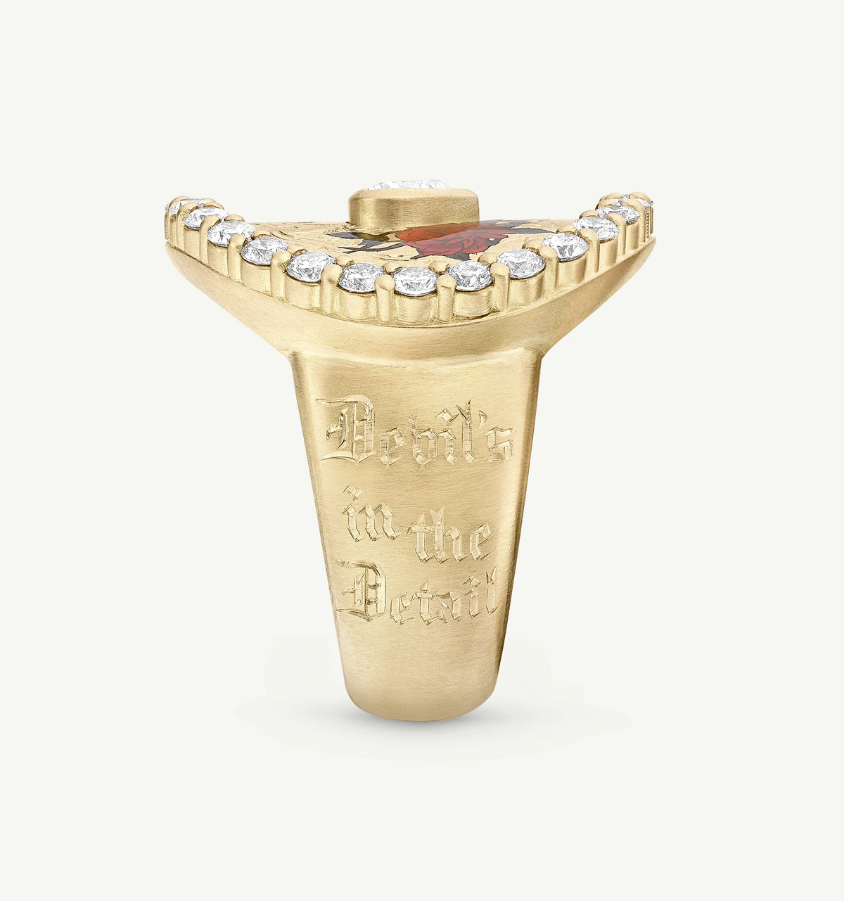 Gold signet ring with engraved lettering and a red stone accent, featuring a row of small diamonds along the top.