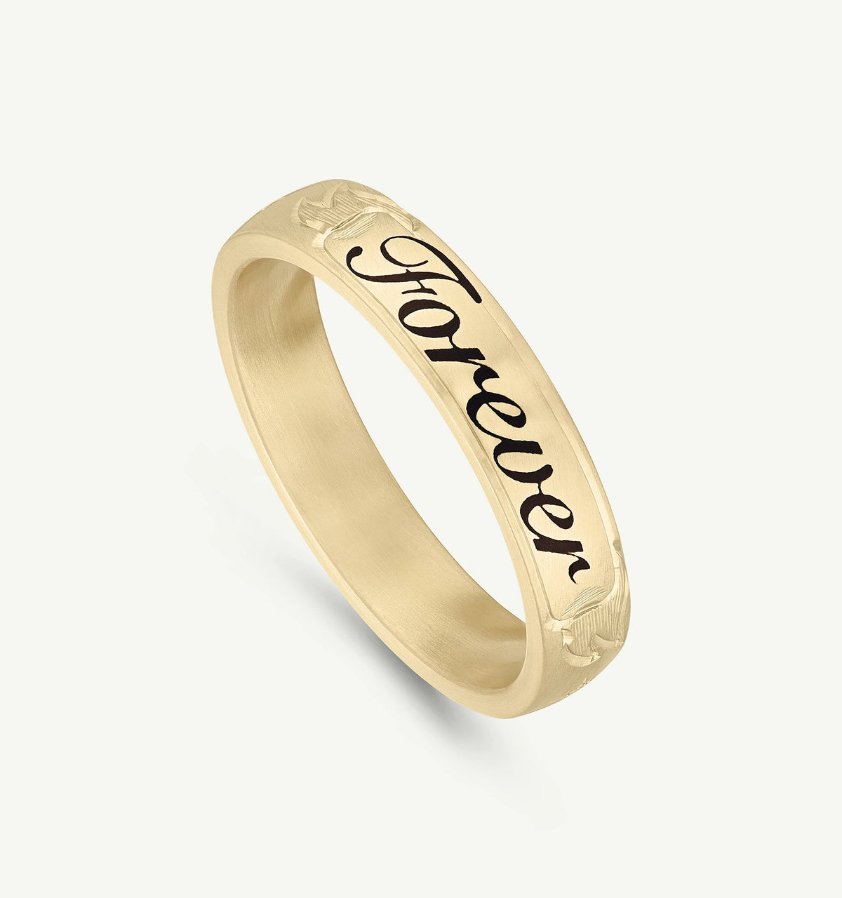 Gold ring featuring the word "Forever" engraved and framed with floral motifs.