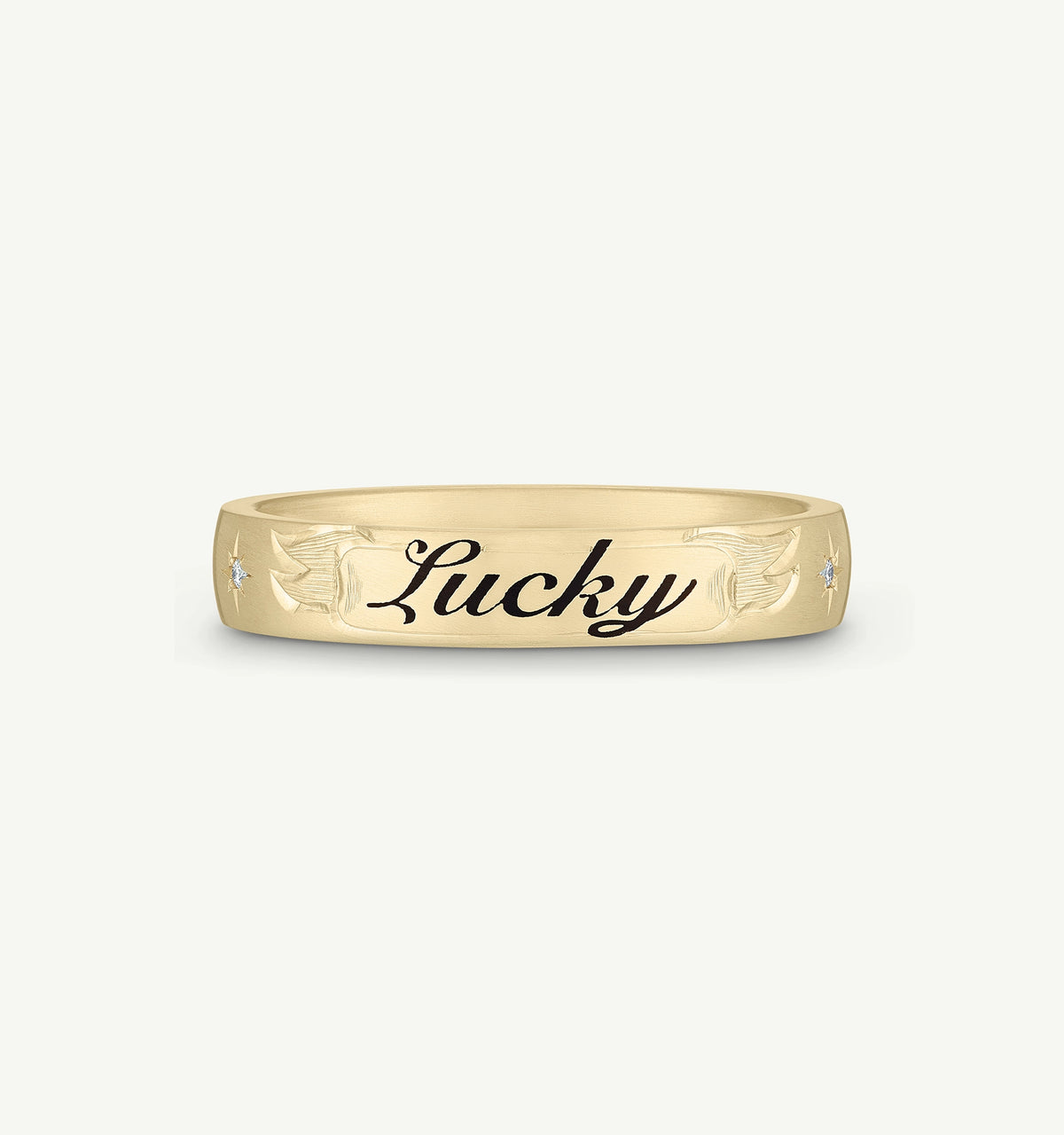 Gold ring with engraved "Lucky" text and decorative motifs, featuring small diamonds on either side.