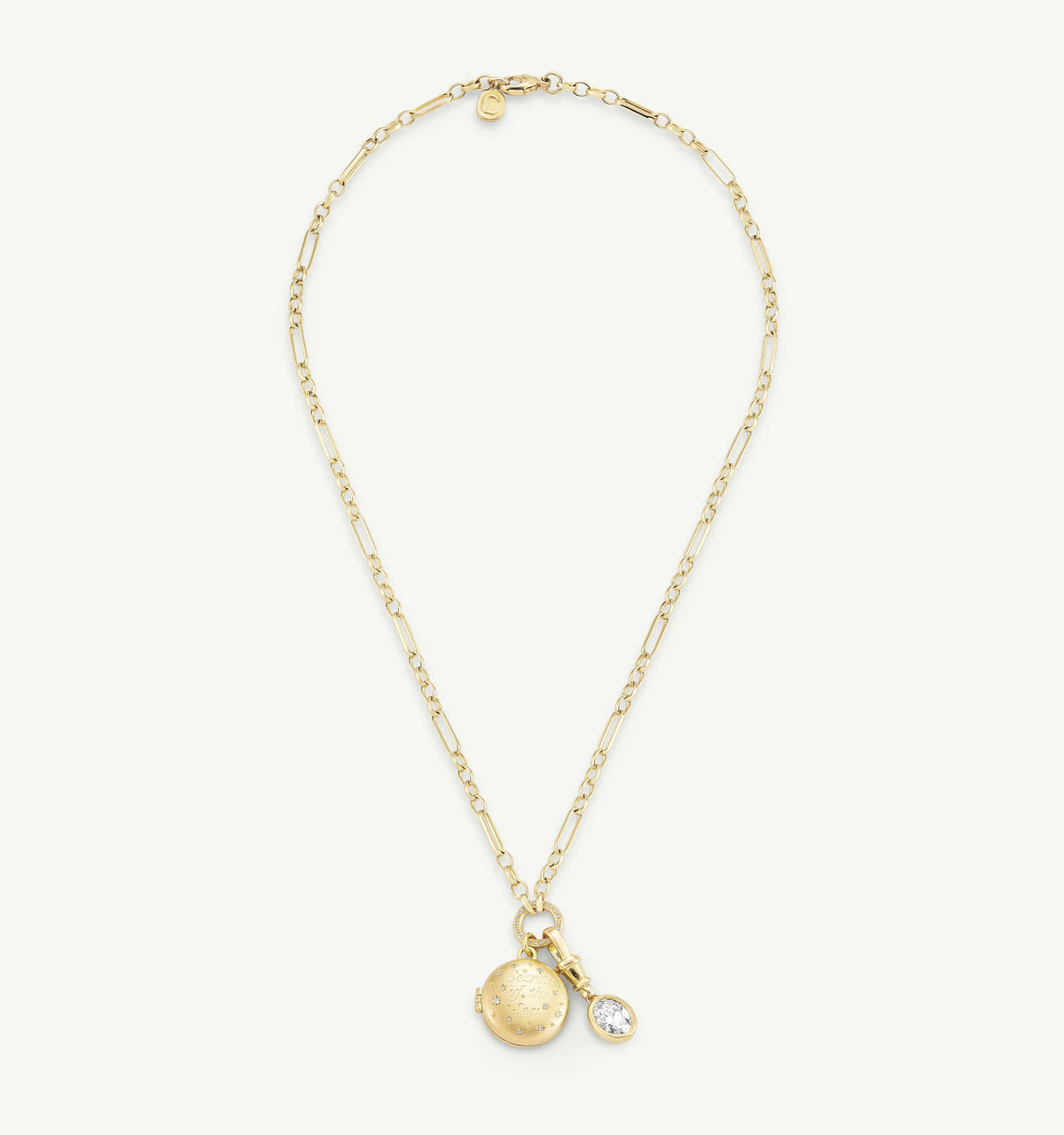 Gold necklace featuring a round pendant with textured detailing and a clear diamond accent.
