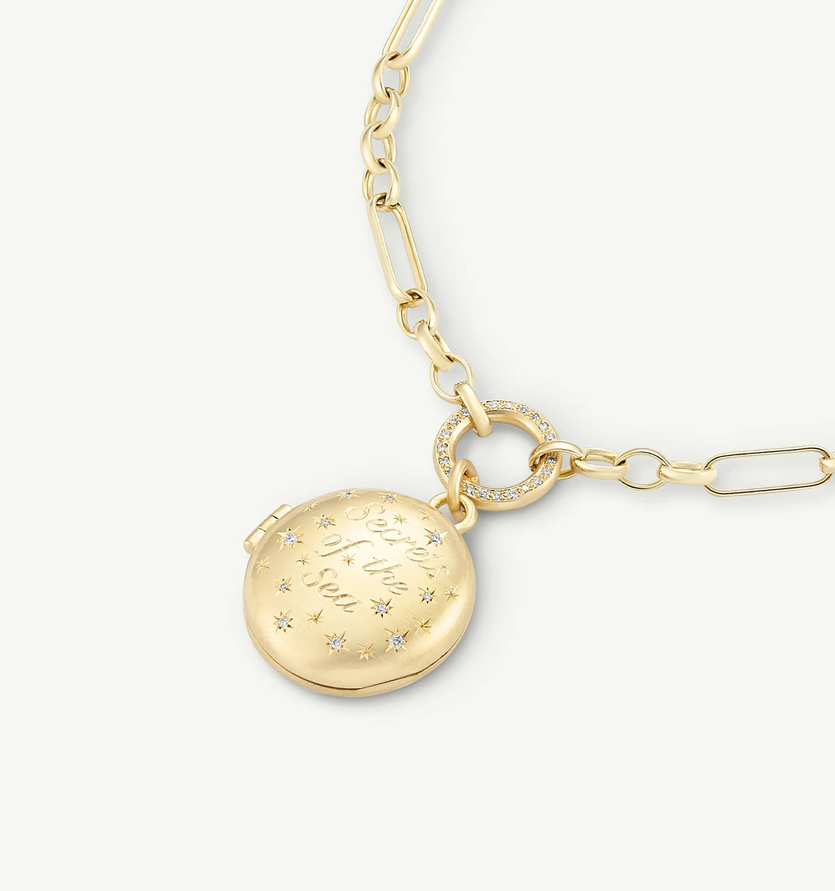 Gold locket necklace with engraved design, featuring a chain link and decorative ring.