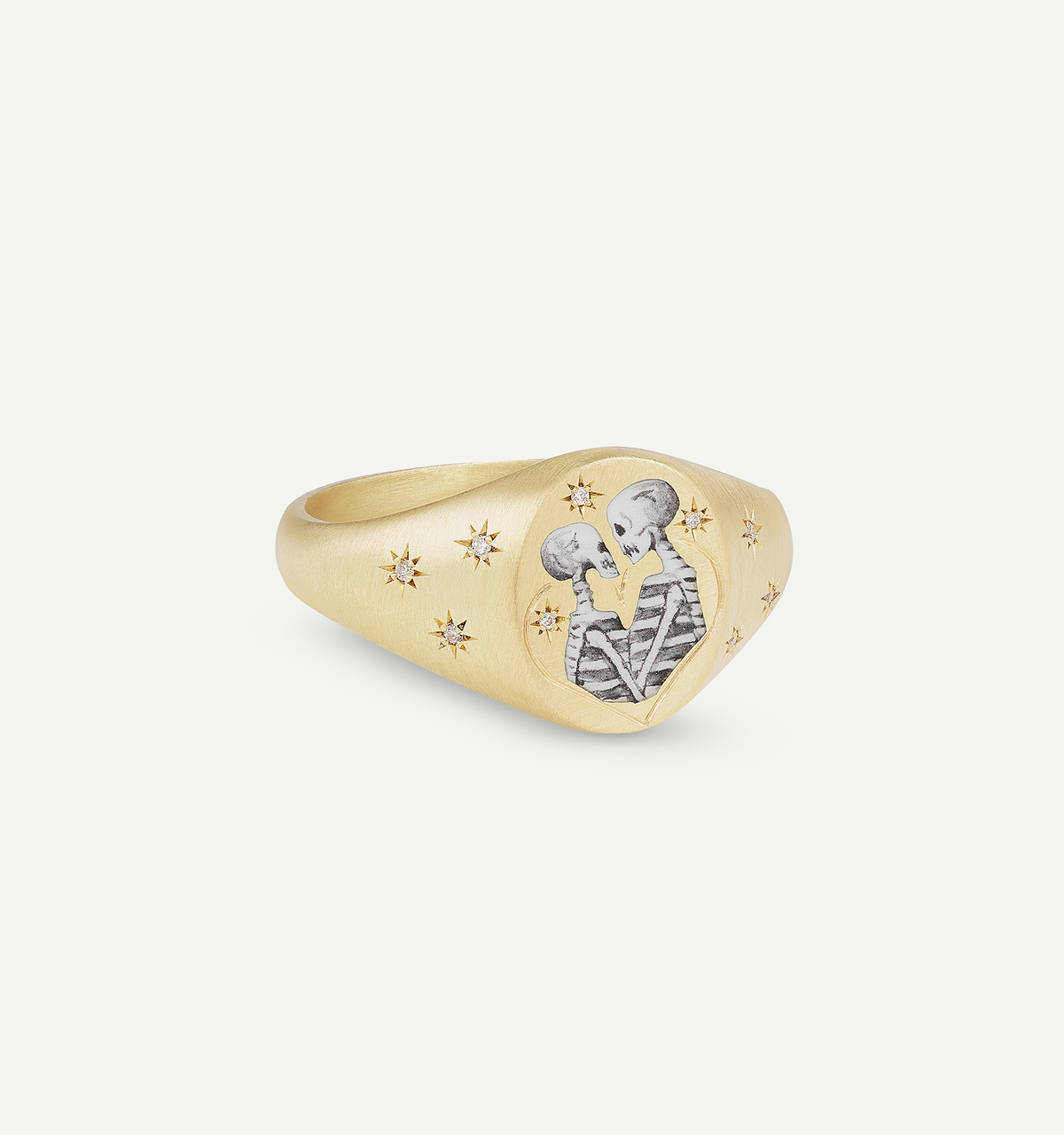Gold signet ring featuring engraved skeletons with star motifs.