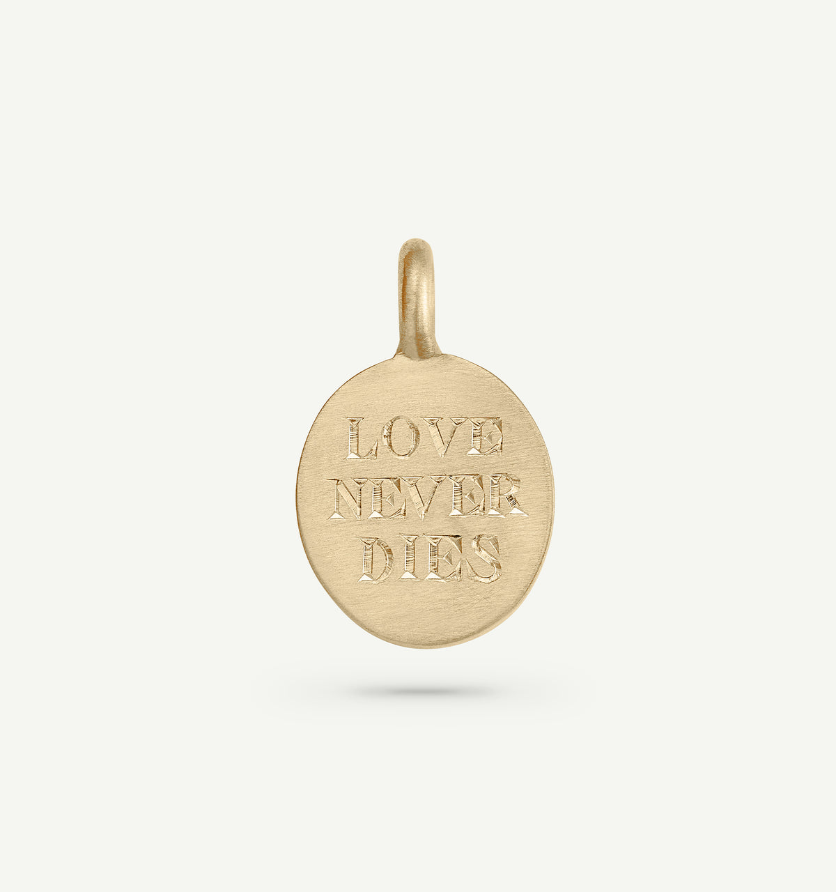 Gold pendant featuring the engraved words "LOVE NEVER DIES" on a smooth circular surface.