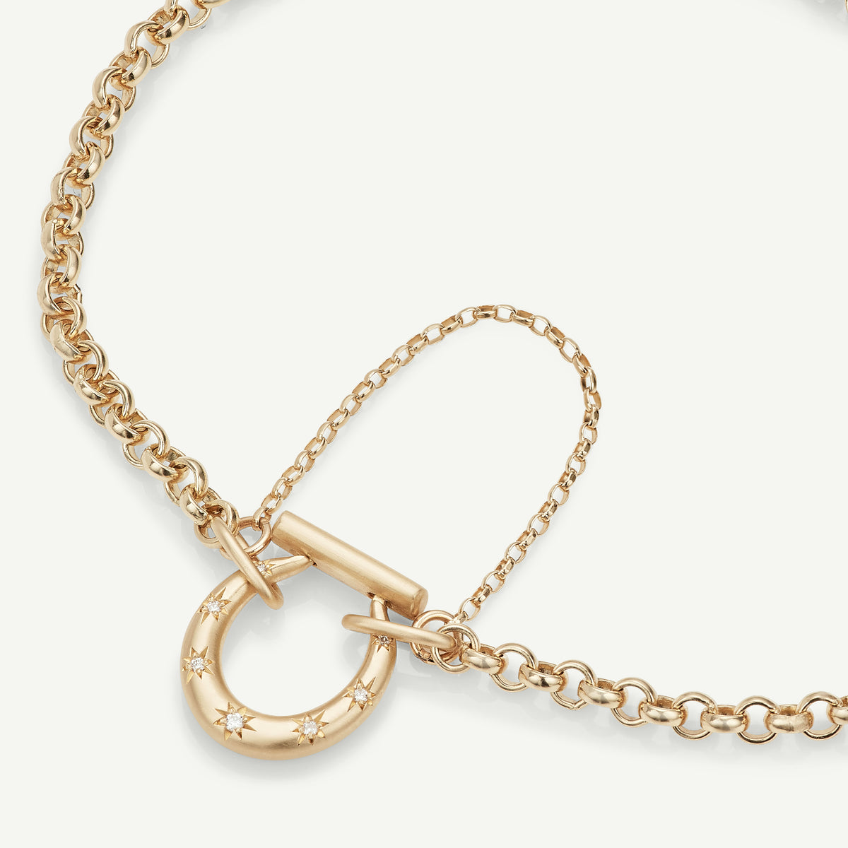 Gold chain necklace featuring a large gold clasp with stars.