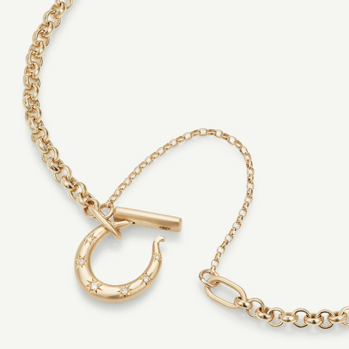 Gold chain bracelet featuring a crescent moon clasp adorned with diamonds.