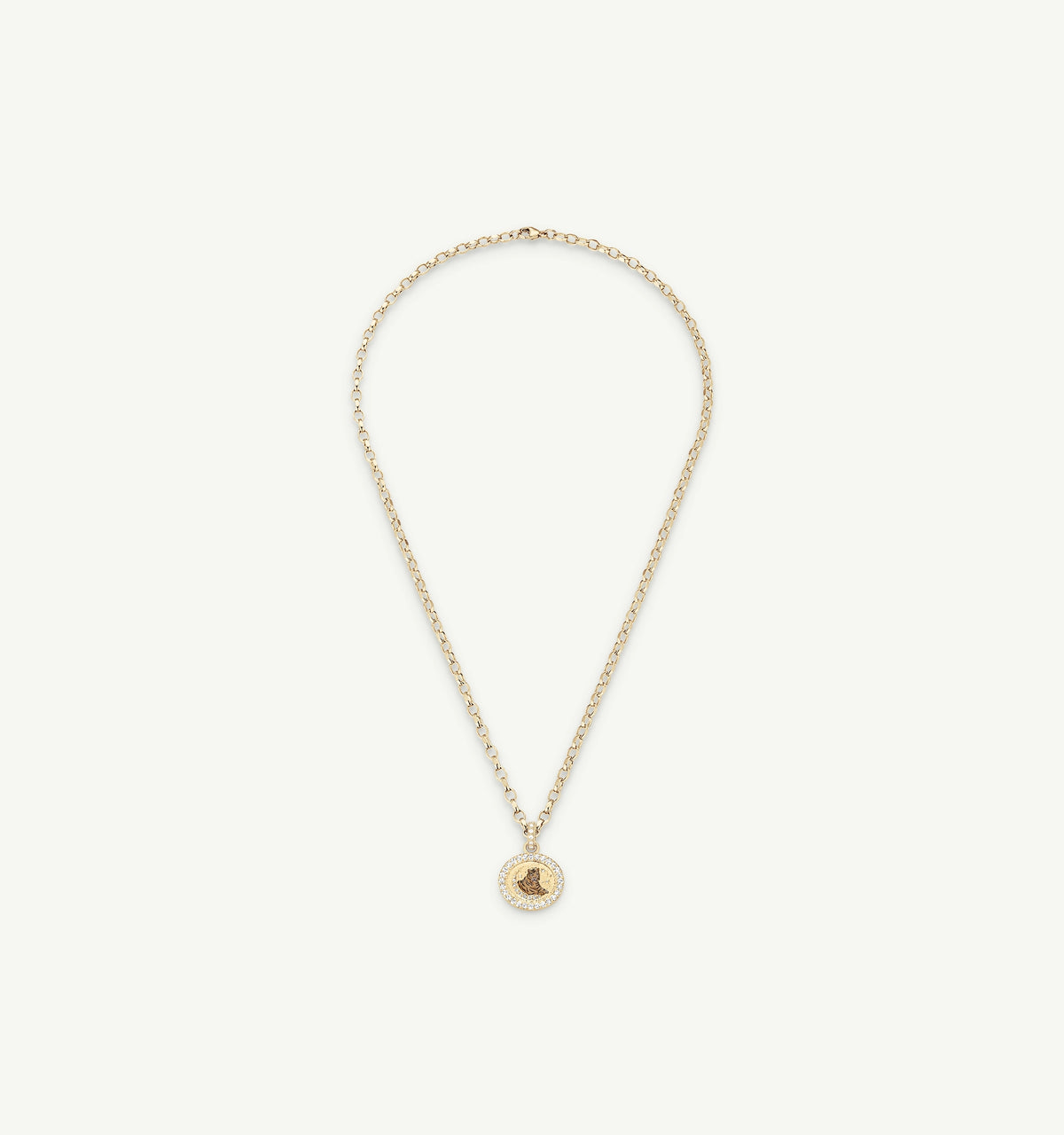 Gold necklace featuring a circular pendant with an engraved design and a halo of pavé-diamond.