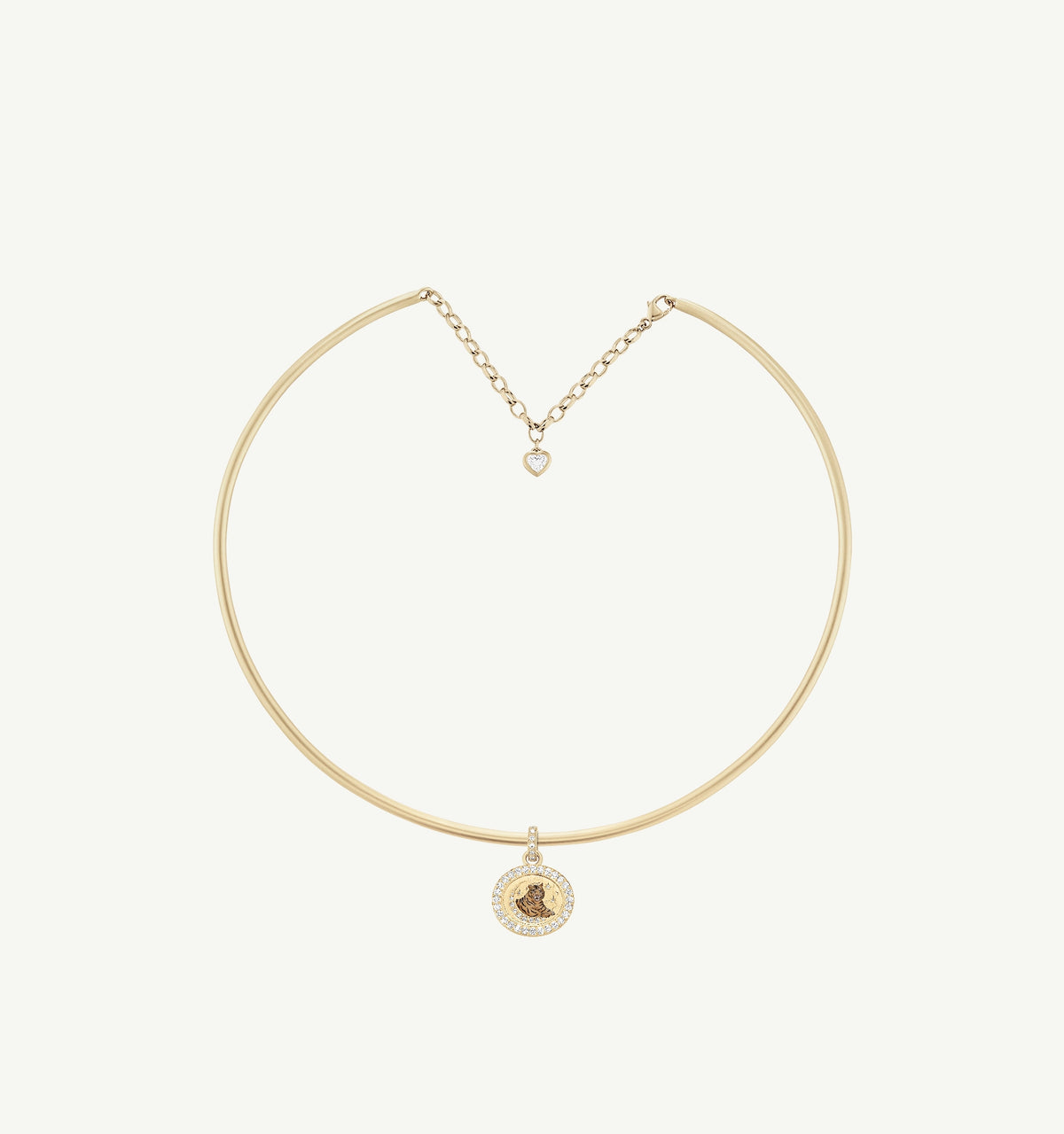 Gold choker necklace with a round pendant featuring a floral design and a small heart charm.