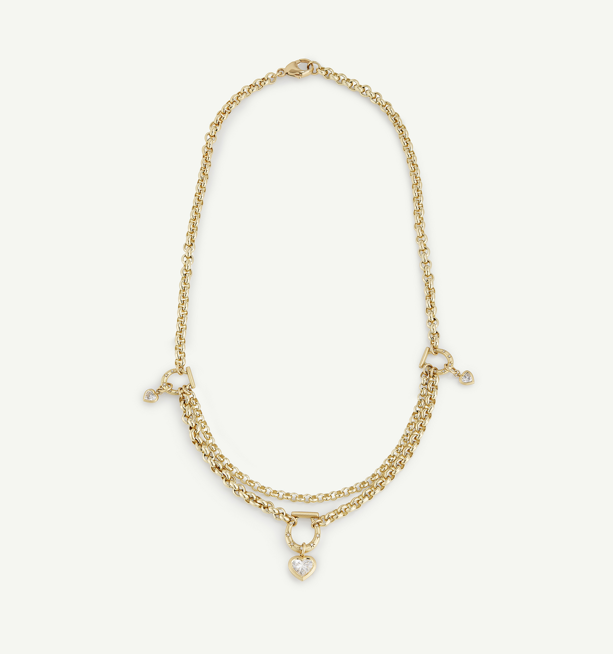 Gold necklace featuring layered chains and a heart pendant with a diamond.