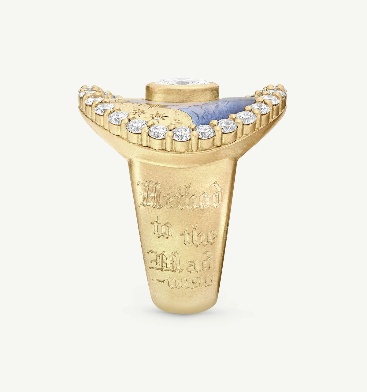 Gold ring featuring blue enamel and diamond accents, engraved with "Method to the Mad."