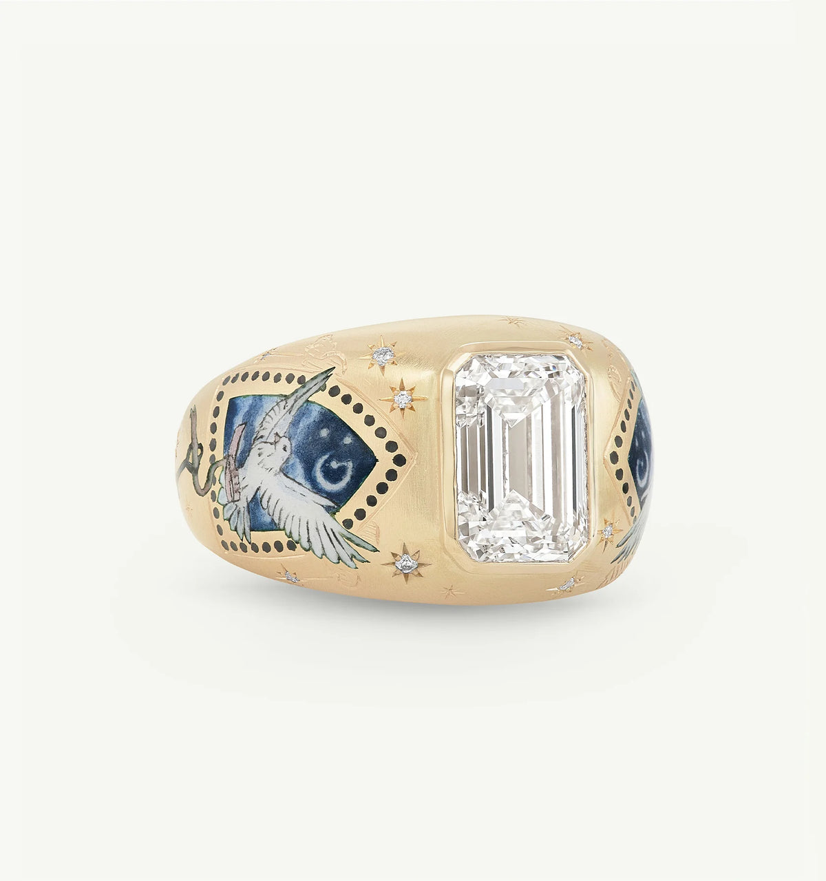 Gold ring featuring an emerald-cut diamond and hand-painted motifs of a bird and stars.
