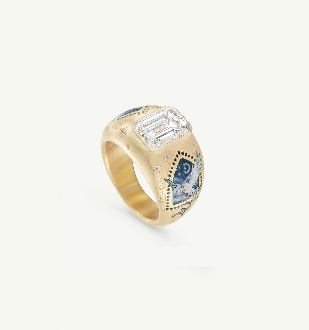 Gold ring featuring an emerald-cut stone and intricate blue enamel designs, including a dove and celestial motifs.