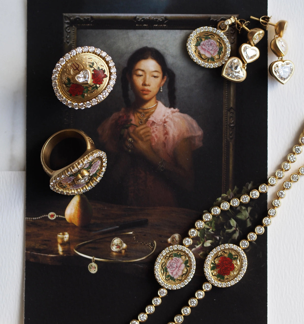 Gold ring with floral design, gold bracelet with rose motifs, and heart-shaped earrings on an art background.