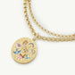 Gold necklace with a decorative pendant on a white background