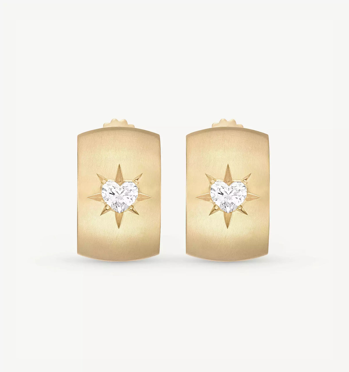 Gold earrings featuring a heart-shaped diamond in the centre and a star motif on a brushed gold surface.