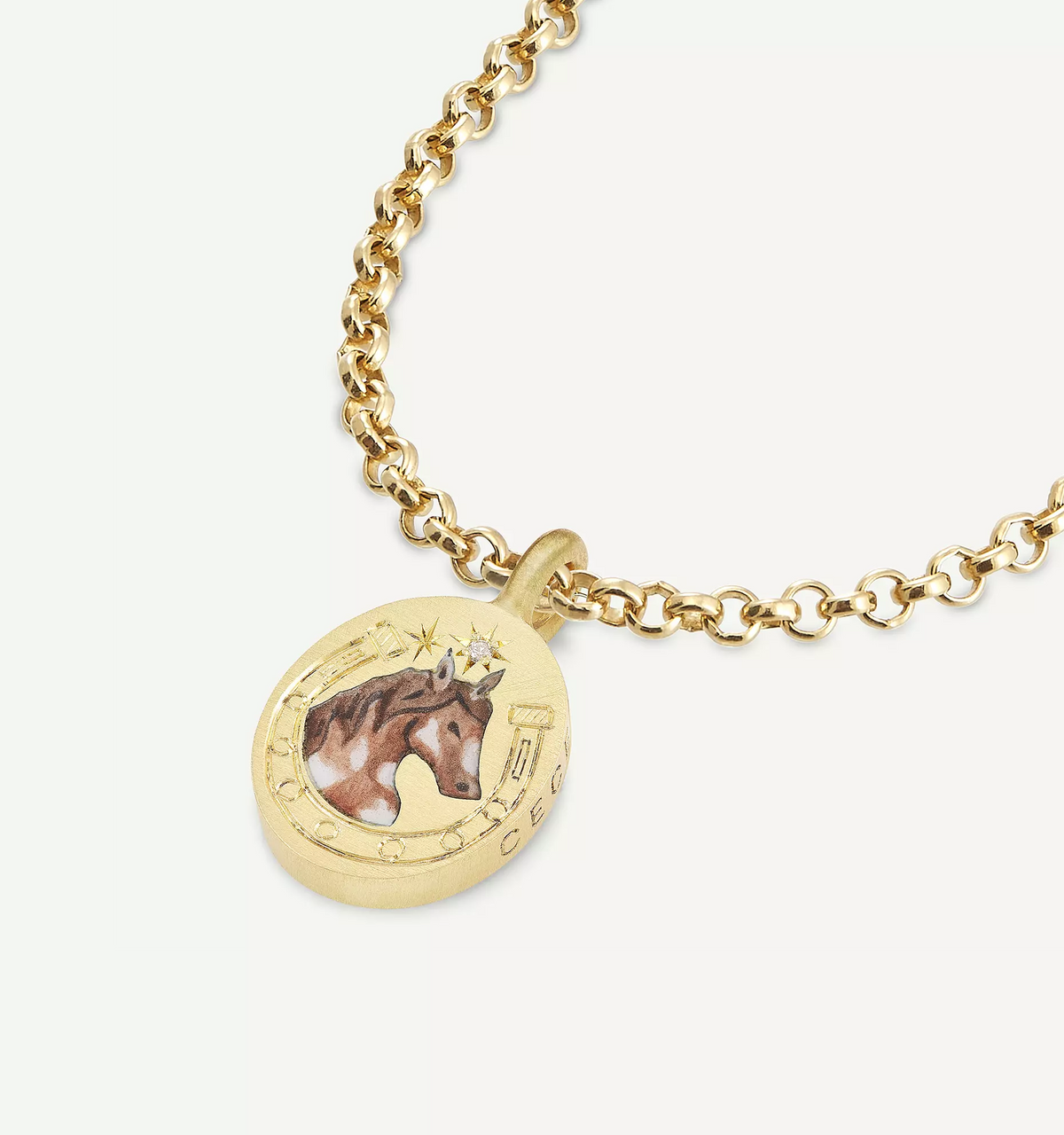 Gold pendant necklace featuring a horse motif in enamel on a textured round charm.