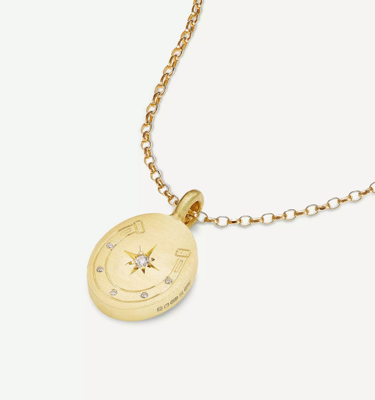Gold pendant necklace featuring a compass design with a central diamond and decorative accents.