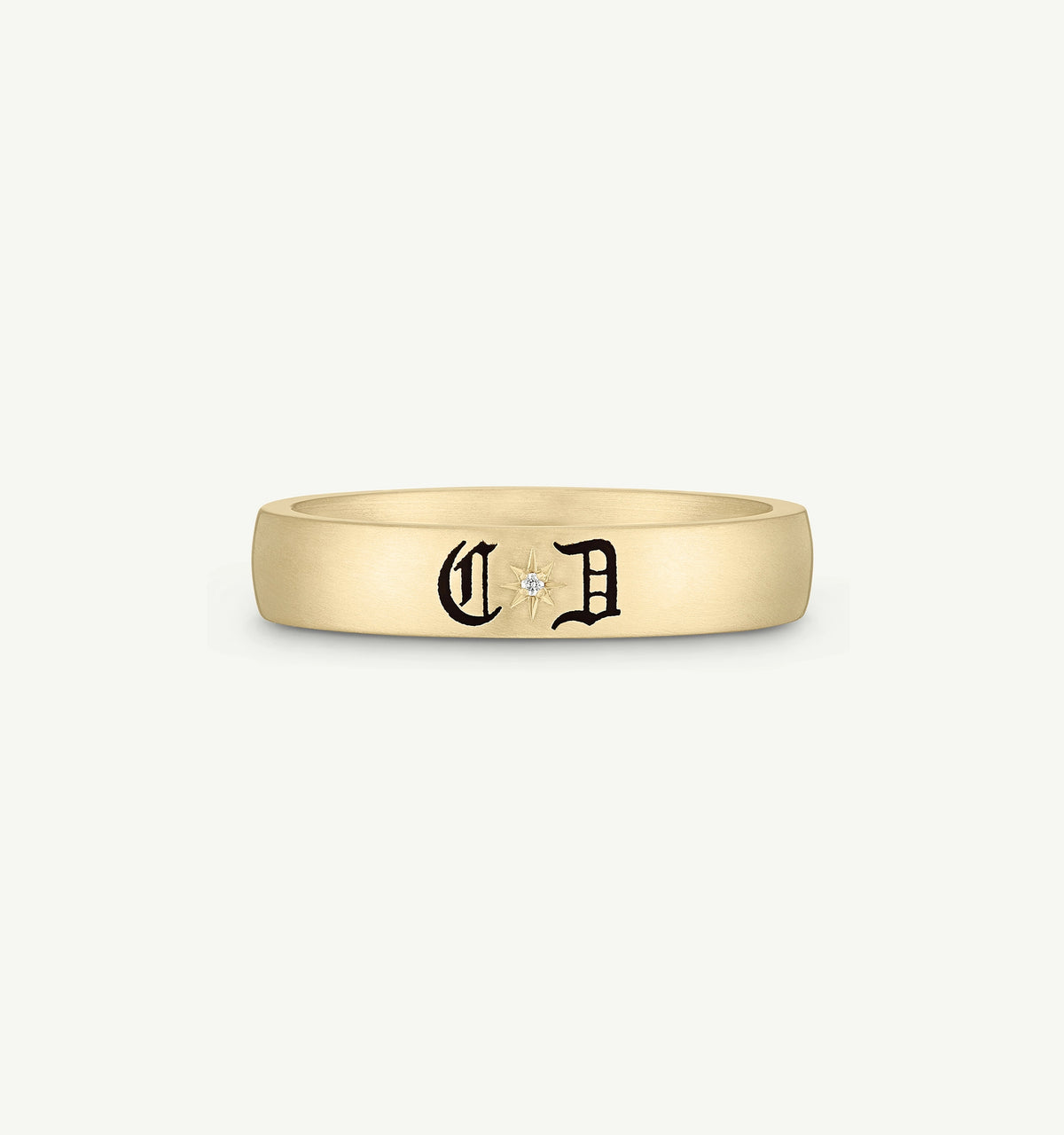 Gold ring featuring black engraving and a small diamond accent.